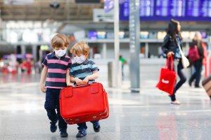 Two little sibling boys wear medical mask
